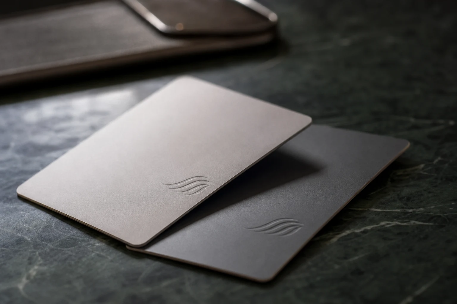 Macro detail of two unbranded NFC contact cards on dark green stone